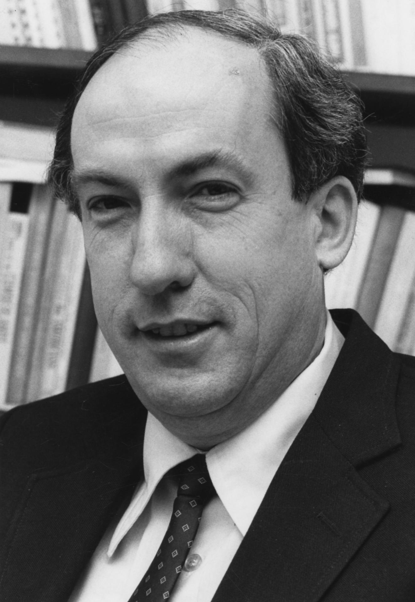 A man poses for a black-and-white portrait.