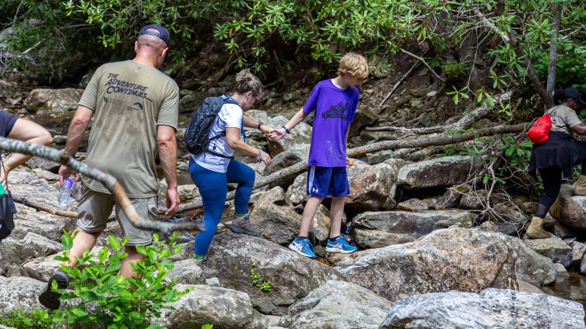 Son helping mother on hike to waterfall. Photo by Angelina Sonoqui