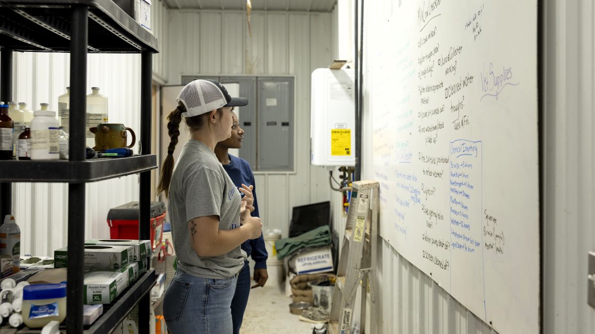 Jillian Lujan (front) and Lillyah Snipes (back) review the daily checklist board. Photo by Sabrina Hounshell.