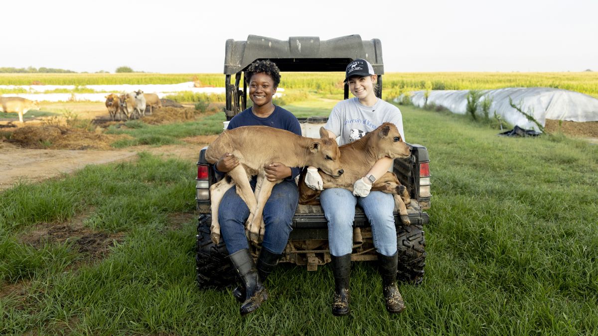 Lillyah Snipes (left) and Jillian Lujan (right) holding two baby calves that were just born. Photo by Sabrina Hounshell.